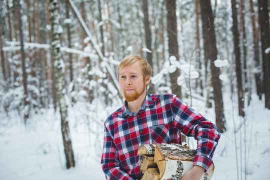 the man in the plaid shirt carries firewood