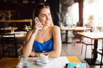 Beautiful woman in cafe using phone