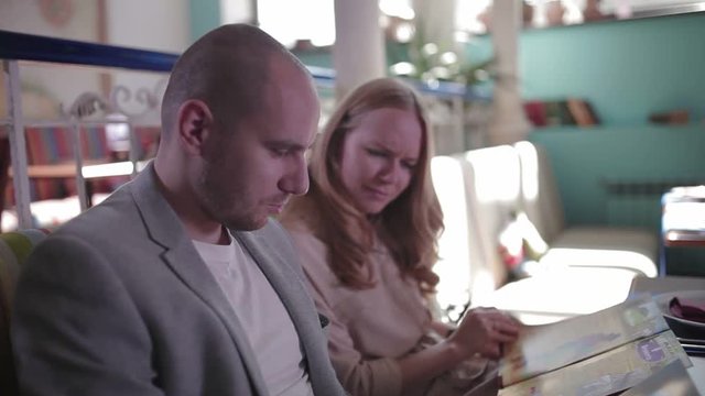 Young couple looking at the menu, choosing dishes