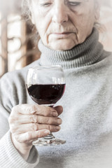 Sad woman holding a glass of red wine