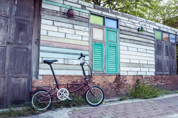 Fototapeta premium Folding Bike with old wooden wall, Vintage color.