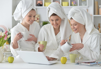 women wearing a white bathrobes with laptop