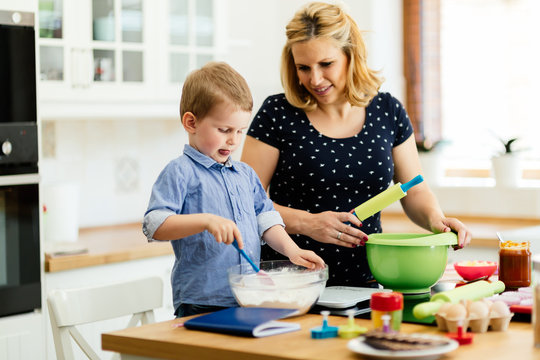 Child helping mother make cookies