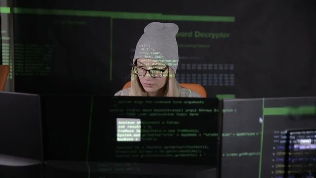 Female hacker working at the computer in dark at night. HD.