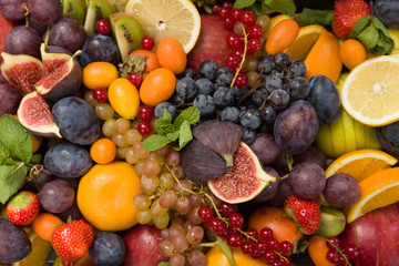 Top view on mixture of different fruit and berries: lemons, figs, grapes, tangerines, apples, strawberry, plums, red current, oranges. Healthy food concept - obrazy, fototapety, plakaty