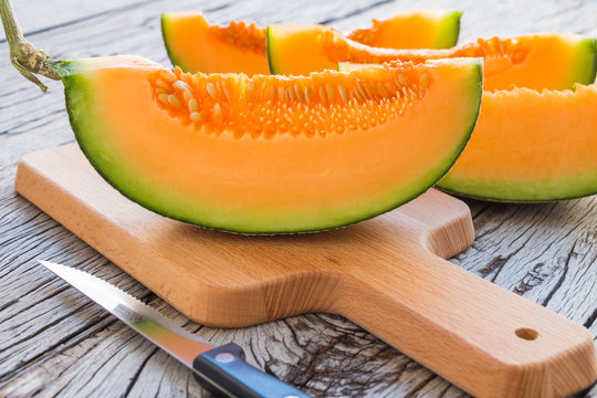 Fresh melons sliced on rustic wooden table