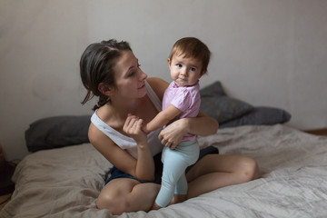 happy loving family. young mother playing with her baby in the b