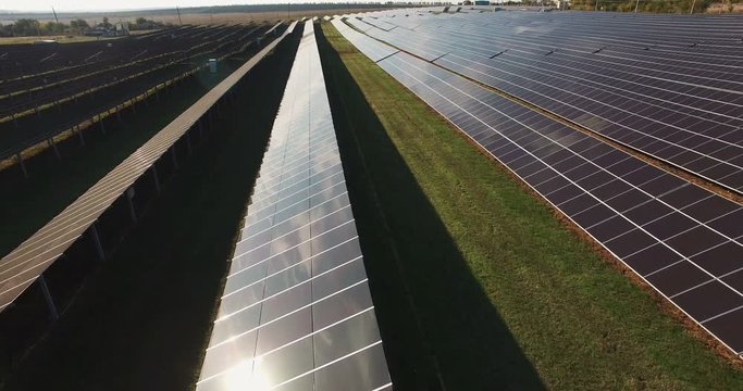 Long rows of photovoltaic panels at a solar farm for converting the energy of the sun to electricity in a concept of renewable energy and natural resources.