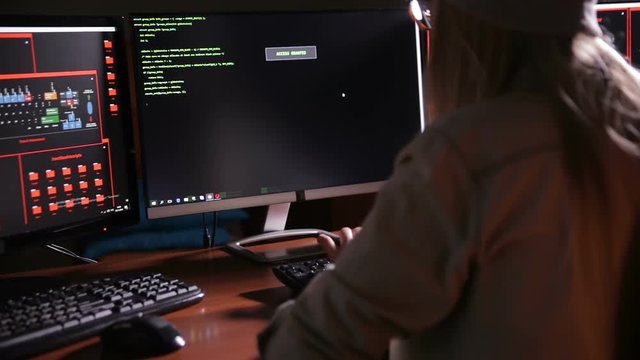 Female computer programmer coding, hacking in dark. HD