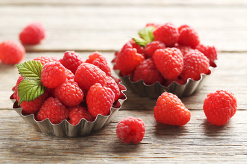 Red raspberries in bowl on a grey wooden table