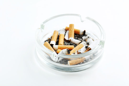 Cigarette butts with ash in ashtray isolated on a white