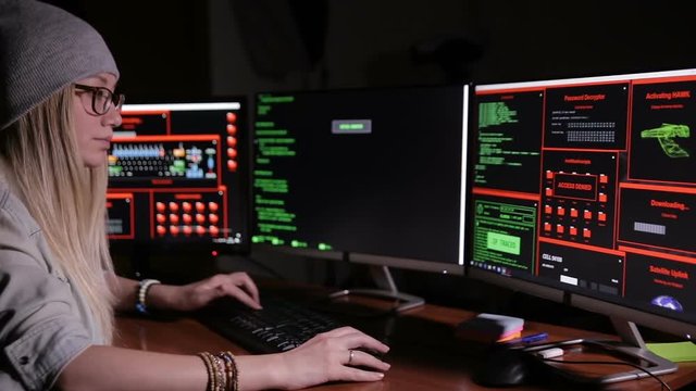 Female hacker working on a computer, coding at night. HD.