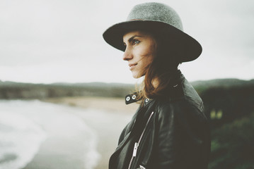 Portrait of young hipster girl enjoying an amazing view of ocean, image with instagram filter, film...