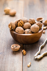 Walnuts in wooden bowl on table with Nutcracker.