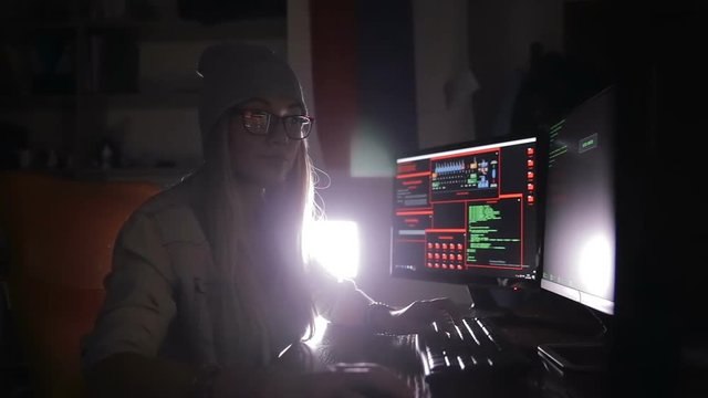 Hacker, programmer working with data code in a dark room. Hackers desk. HD.