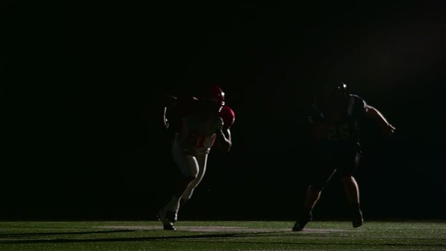 A football player runs past the defense and makes a catch