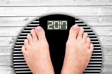 2017 feet on a weight scale, white wooden floor background