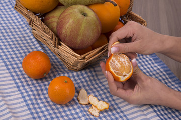 mani di donna che sbuccia un mandarino

