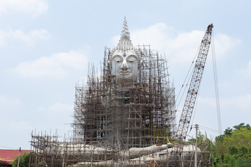 Fototapeta premium Restoration of Buddha with blue sky and white cloud, outdoor