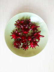 fresh roselle on a green ceramic dish