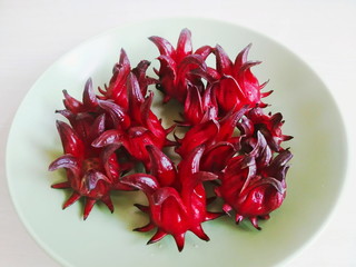 close up shot of fresh roselle on a green ceramic dish