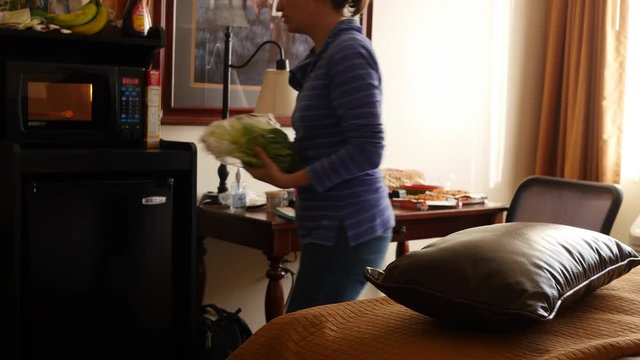 Mother cooking microwave pizzas for dinner in a hotel