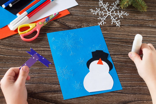 Child paper glued details. The child makes a greeting card with
