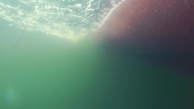 Underwater shot of bubbles passing by on the bottom of boat