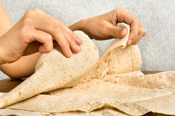 hands tear off a piece of pita bread