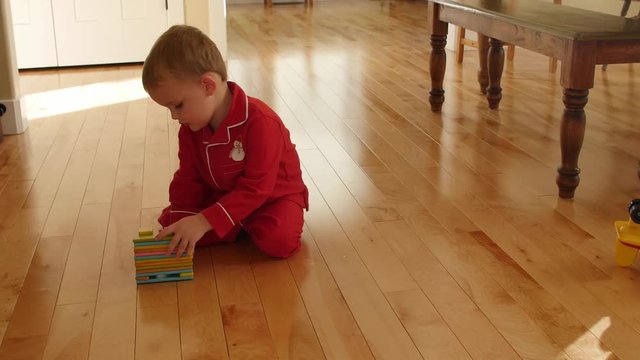 Cute boy plays on floor with magnetic blocks