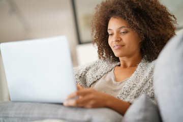 Beautiful woman at home websurfing with laptop computer