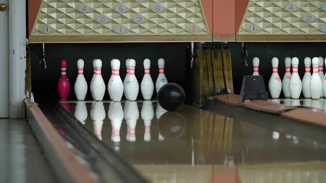 A slow motion shot of ball hitting bowling pins