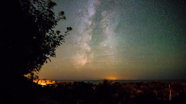 A timelapse shot of an amazing milky way rotating above the ocean coastline at night