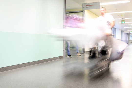 Notfallaufnahme im Krankenhaus - Angeh&ouml;rige folgen dem Krankenbett und Pflegepersonal