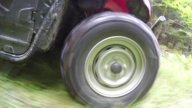Low shot of a four wheeler side by side tire driving through forest