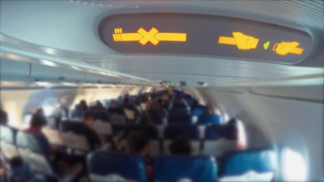 Passengers and a no smoking sign in commercial airplane