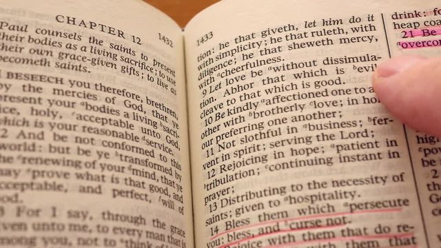 A closeup dolly shot of man reading bible abhor evil