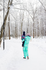 Fototapeta na wymiar Happy family. Mother and child girl on a winter walk in nature.