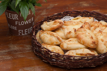 pies in a wicker basket and flower on old wooden table