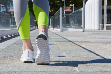 Woman ready to run outdoor in a modern city in a sunny day