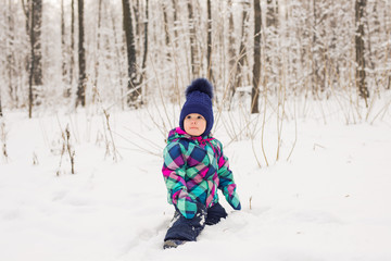 Fototapeta na wymiar Laughing baby girl playing in the snow