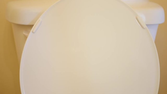 A man flushes the toilet in the bathroom