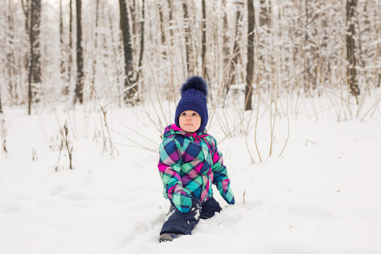 Laughing baby girl playing in the snow