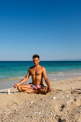 Fototapeta na wymiar Adult male meditation practicing in the morning on the beach, L