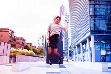 Young beautiful caucasian purple grey hair woman jumping outdoor in the city in back light - happiness, satisfaction, succesful concept