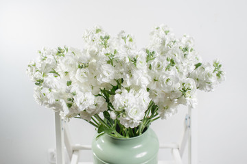 beautiful bouquet white Mattioli bush in in vintage vase mint color. colorful mix flower