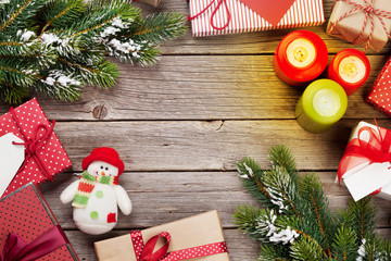 Christmas gift boxes and candles on wooden table