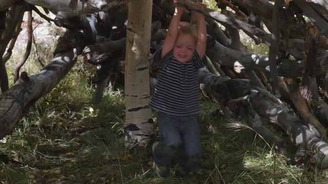 Boy playing in a hut built from sticks