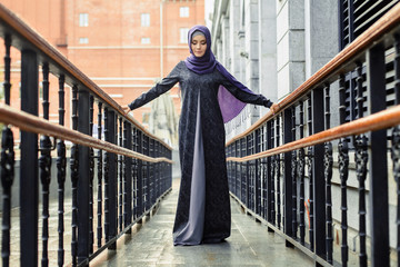 Islamic beautiful woman in a Muslim dress standing on a European street