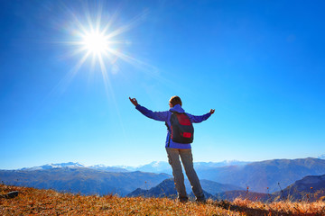 cheering  woman backpacker at sunrise mountain peak
